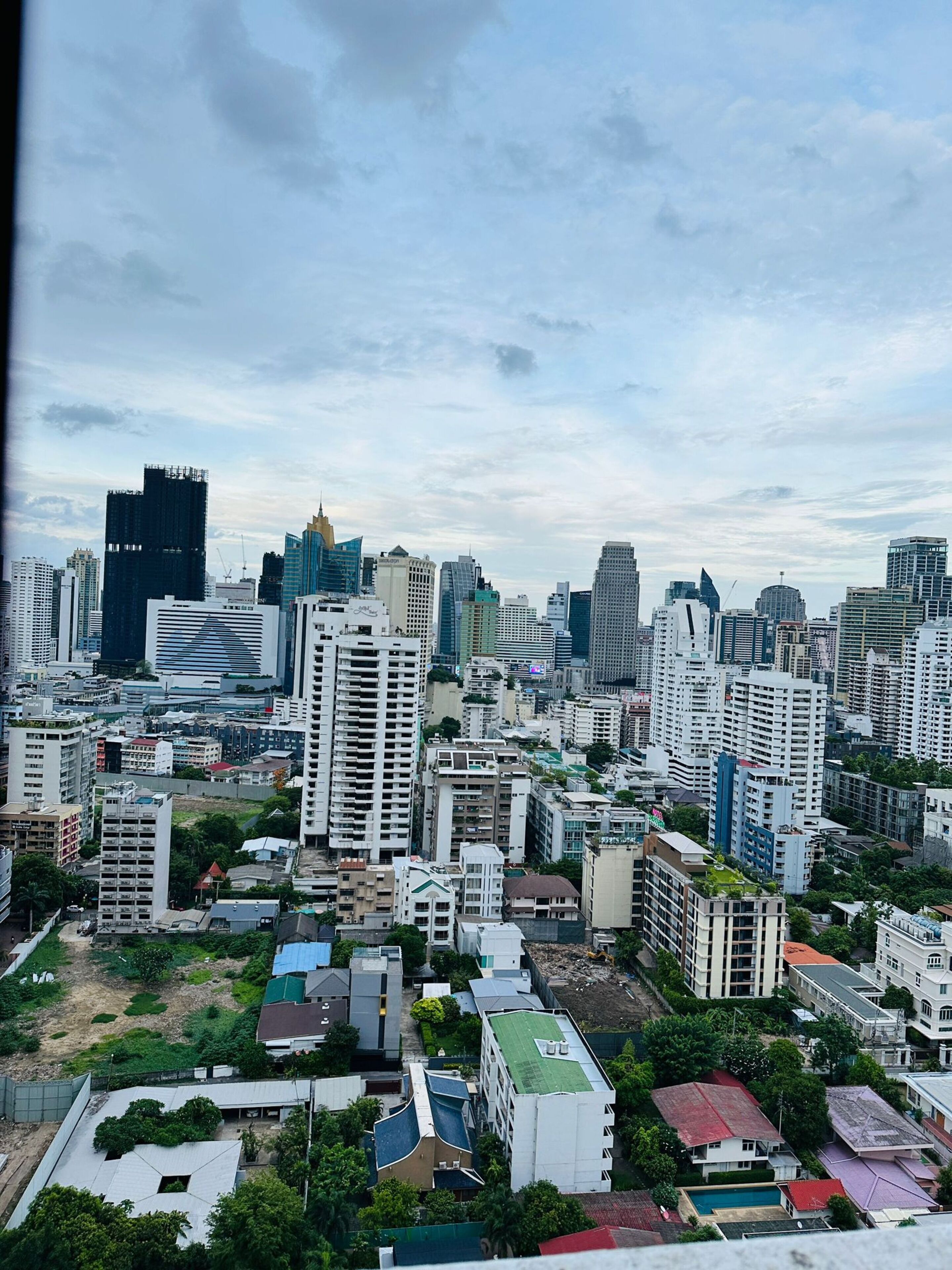 A cityscape with a variety of high-rise buildings, including modern skyscrapers and older residential structures.