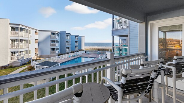 A balcony with a pool, white railings, and a view of the ocean. - A Place at the Beach III 9520-2B Summer Escape at Myrtle Beach Ocean View Condo (Myrtle Beach)
