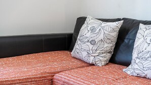 A sectional sofa with patterned pillows and a textured orange cushion. - San Niccolò 31 - One Bedroom Apartment, Sleeps 2 (Firenze)