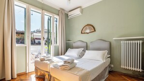A hotel room with a bed, a chair, a window, and a radiator. - Maggio 54 - Three Bedroom Apartment, Sleeps 6 (Florence)