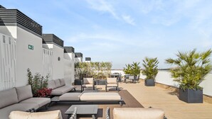 A rooftop terrace with outdoor seating, including sofas and chairs, and potted plants. - Truliving Vallecas by Habyt (Madrid)