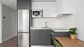 A modern kitchen with a built-in refrigerator, microwave, and sink.
