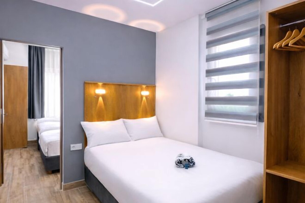 A hotel room with a bed, a wardrobe, and a mirror.