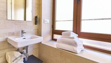 Habitación doble superior | Baño | Ducha, secador de pelo, toallas y jabón
