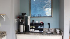 A kitchen with a coffee machine, a sink, and a framed artwork on the wall. - Riverfront Inn (Conway)