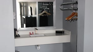 A modern bathroom with a white sink, mirror, and towel rack. - Riverfront Inn (Conway)