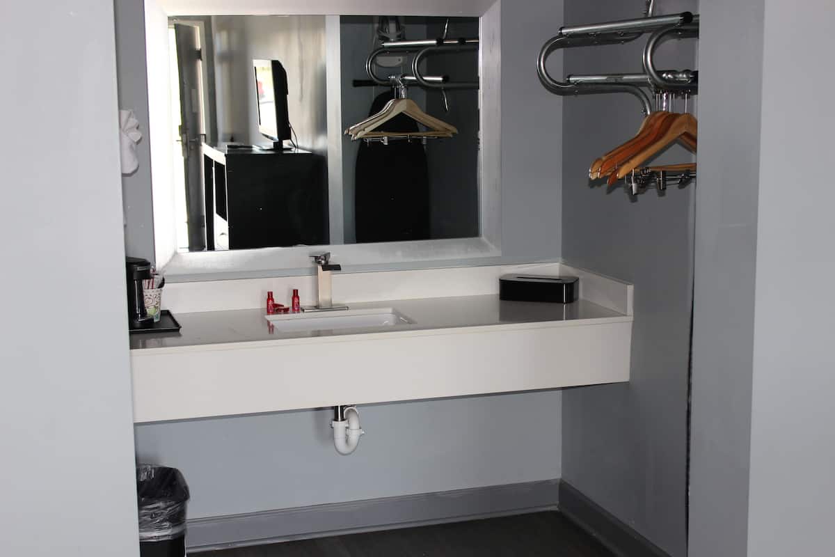 Une salle de bain moderne avec un lavabo blanc, un miroir et un porte-serviettes.