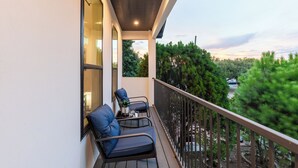 A balcony with two chairs and a small table, overlooking a garden and a road. - Beautiful, Cozy, Contemporary 4BR near Downtown Dallas
 (Dallas)
