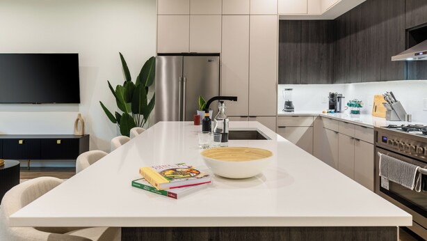 A modern kitchen with a central island, stainless steel appliances, and a flat-screen TV mounted on the wall. - Beautiful, Cozy, Contemporary 4BR near Downtown Dallas
 (Dallas)
