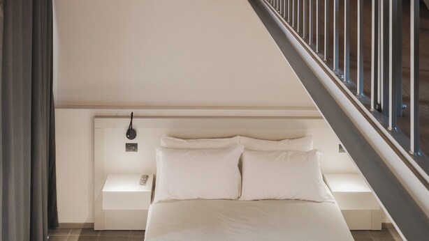 A modern bedroom with a large bed, a nightstand, and a wall-mounted lamp. - Valèt guesthouse, four rooms and sleeps 12, half an hour from Alba (Moasca)