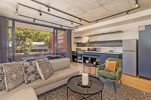 Un salon moderne avec un canapé, une table basse et une vue sur l’extérieur.