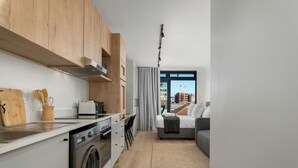 A modern apartment with a kitchen, a dining area, and a living room. - The Sage l Elegant Studio in Vibrant Sea Point (Cape Town)