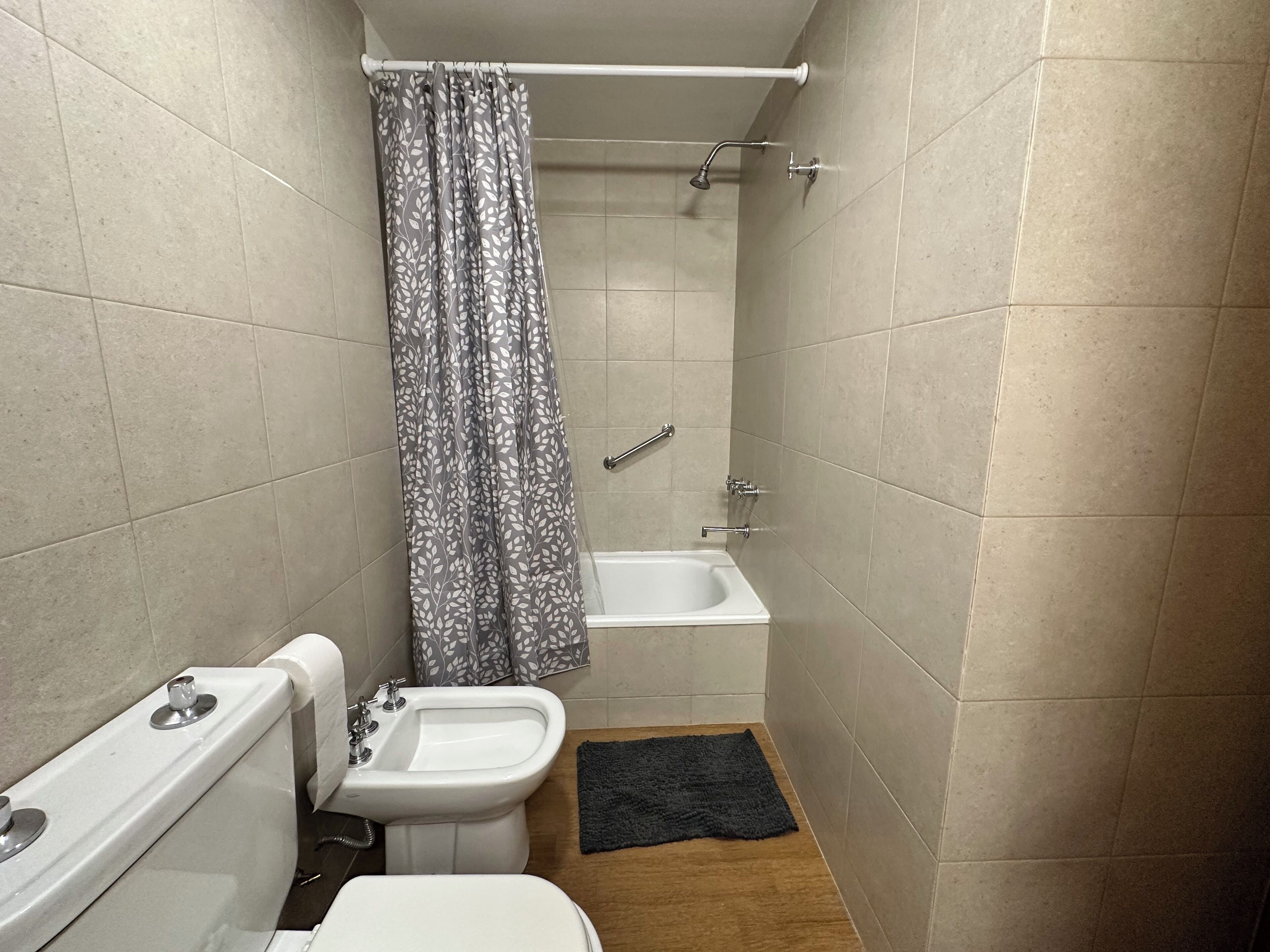 A small bathroom with a toilet, bidet, and shower.