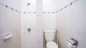 Pieni kylpyhuone, jossa on wc, suihku ja pyyheteline.