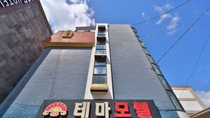A building with a sign that reads "Motel Theme" and a logo with a sun and waves. - Thema Motel (Sacheon)