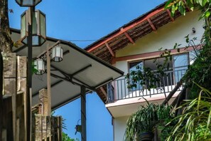 A building with a balcony, a street lamp, and some greenery. - fengchaominsu (Emeishan City)