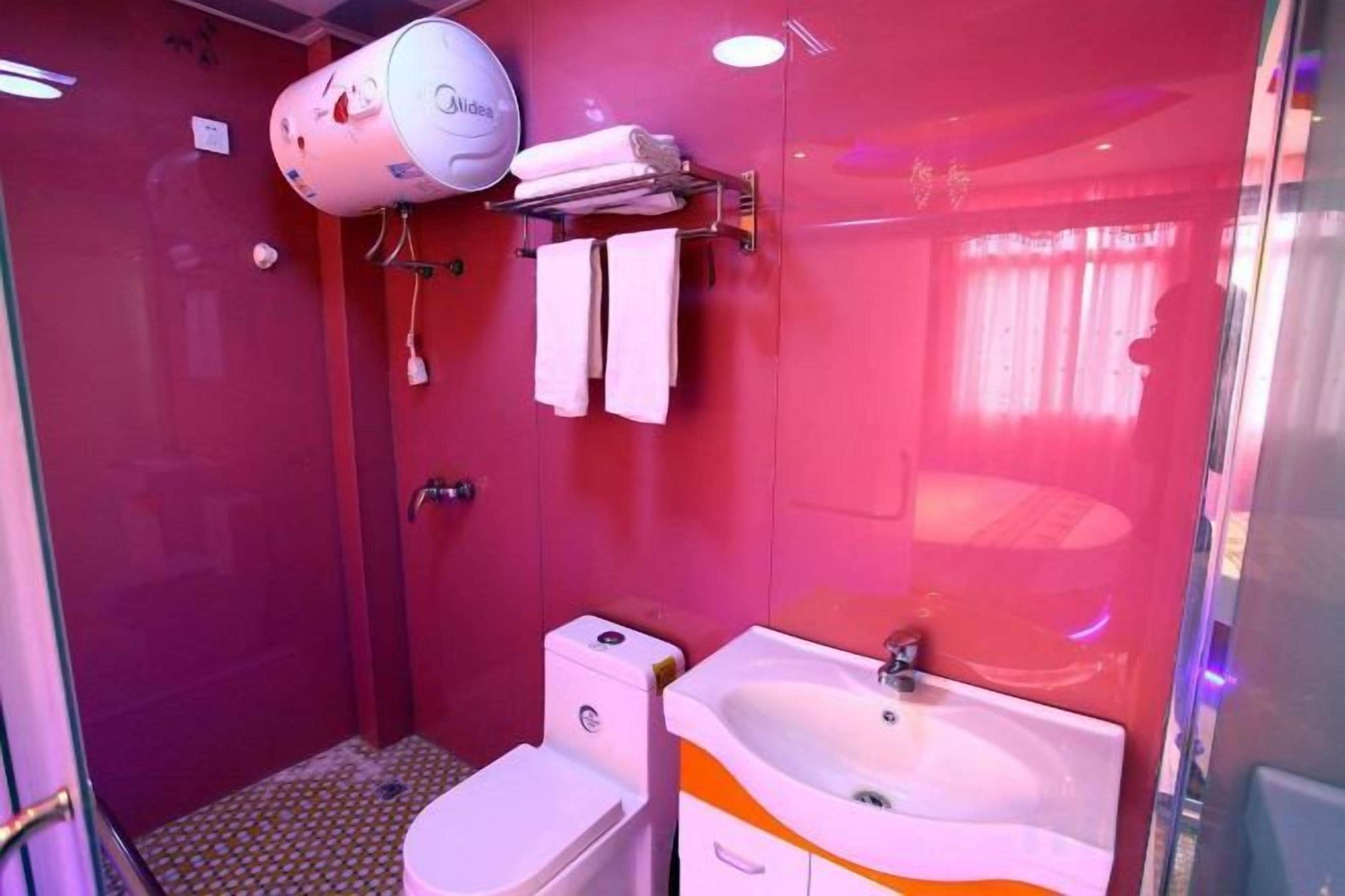 A bathroom with a toilet, sink, and shower.