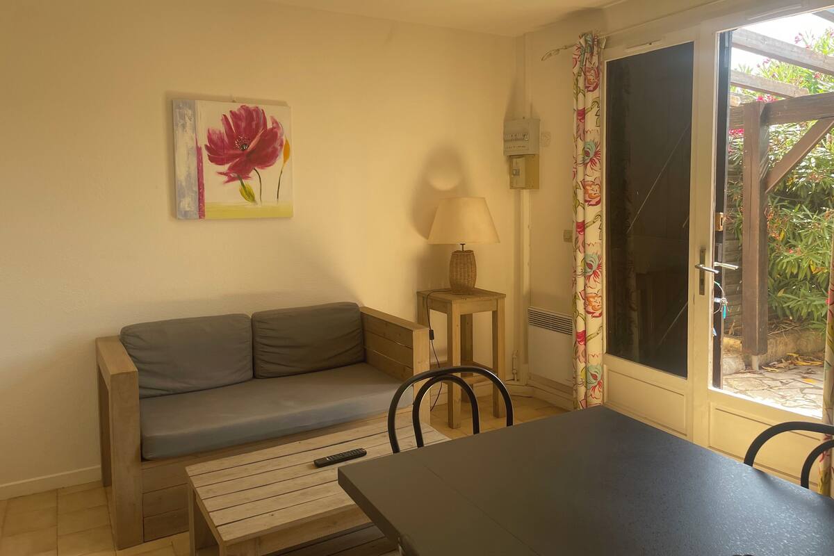 A cozy room with a sofa, a table, a lamp, and a window with a curtain.