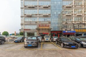 A multi-story building with a parking lot in front. - Junrun Hotel (Guangzhou)