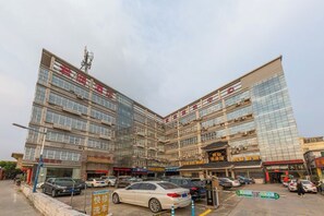 Un immeuble commercial à plusieurs étages avec un parking situé à l’avant.