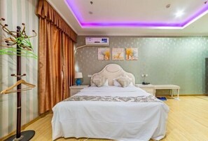 Ein Schlafzimmer mit einem Bett, einem Nachttisch, einer Lampe, einer Wandklimaanlage und einer Deckenleuchte.