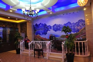 A lobby with a mural, a chandelier, and potted plants. - Sunshine 100 Holiday Hotel (Changyi District Government Branch, Zhongxing Street, Jilin) (Jilin City)