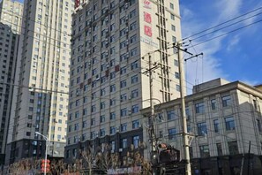 A high-rise building with multiple floors and a clear sky. - Sunshine 100 Holiday Hotel (Changyi District Government Branch, Zhongxing Street, Jilin) (Jilin City)