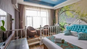 A bedroom with a bed, a ceiling mural, a staircase, wicker chairs, and a view of greenery outside.