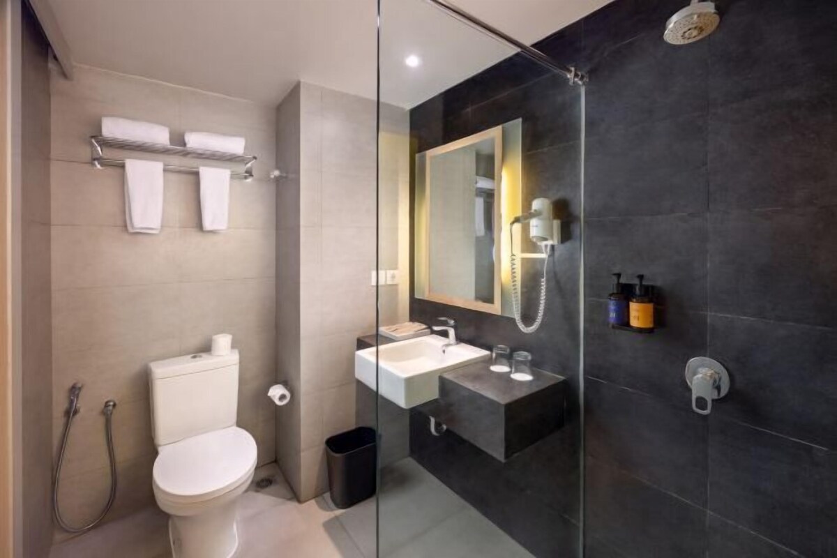 A modern bathroom with a toilet, sink, and shower.