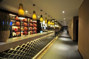 A hotel lobby with a long reception desk, pendant lighting, and a seating area with rows of chairs. - Rongchen International Holiday Hotel (Zhangjiakou)
