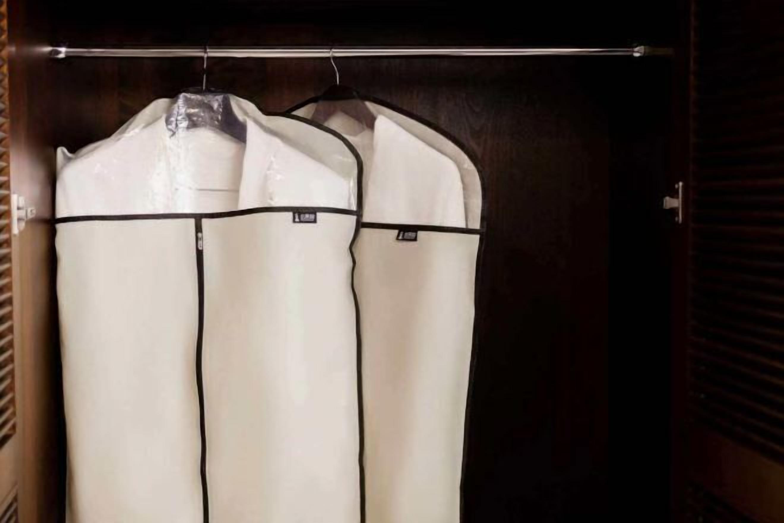 A closet with three hanging garments.
