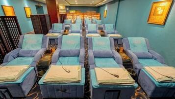 Relax in a serene space with massage therapy chairs, framed artworks, and a cozy atmosphere.
