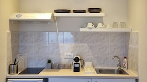 A compact kitchen with a built-in dishwasher, a coffee maker, and a sink. - TOLO BLUE BAY (Nafplio)