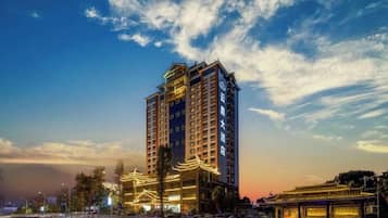 A high-rise hotel with multiple floors, large windows, and a well-lit facade.