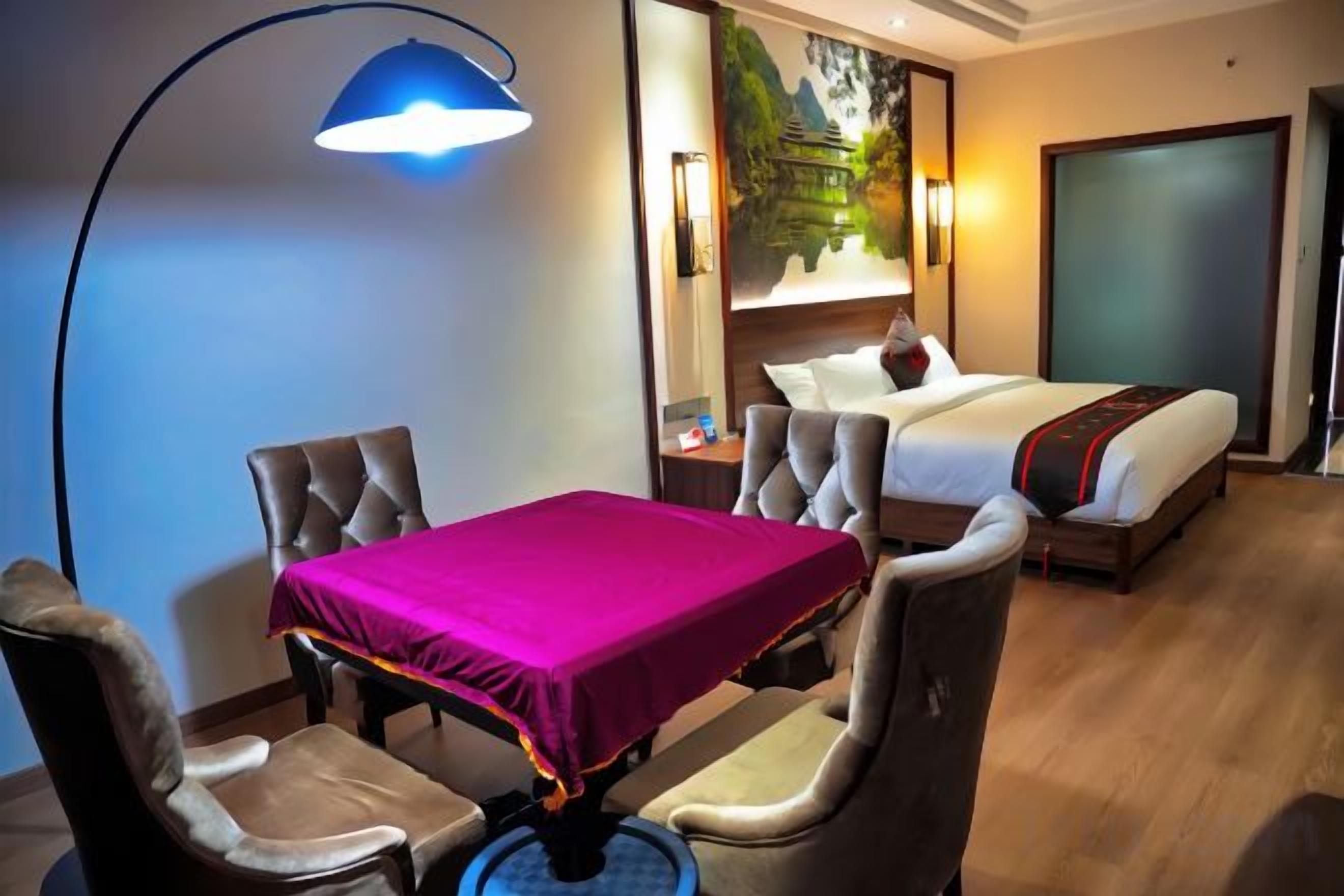 Una camera d'albergo con un letto, un tavolo con tovaglia e due sedie.