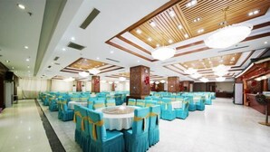 A banquet hall with round tables and chairs, wooden ceiling panels, and chandeliers. - Yunding International Hotel (Sanjiang)