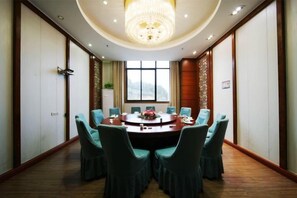 A conference room with a round table, chairs, and a chandelier. - Yunding International Hotel (Sanjiang)