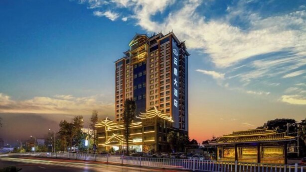 A high-rise hotel with multiple floors, a traditional architectural style, and a well-lit facade. - Yunding International Hotel (Sanjiang)