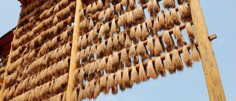 Une structure traditionnelle avec une ossature en bois et des éléments suspendus, probablement utilisée pour le séchage ou le stockage.