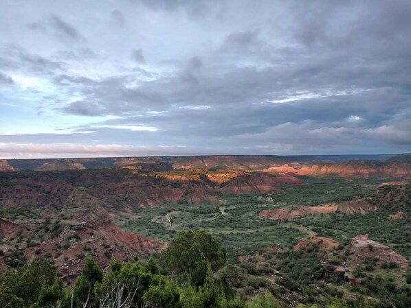 A canyon landscape with rugged terrain and sparse vegetation.