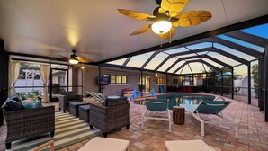 A covered outdoor area with a pool, wicker furniture, and ceiling fans. - Palm Paradise Retreat - Heated Pool, Spa, Mini Golf (Seminole)