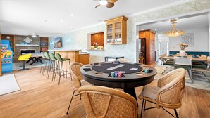 A spacious room with a poker table, chairs, and a ceiling fan. - Palm Paradise Retreat - Heated Pool, Spa, Mini Golf (Seminole)