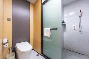 A modern bathroom with a toilet, a glass shower enclosure, and a towel rack. - Wenhui Hotel (Shanghai)