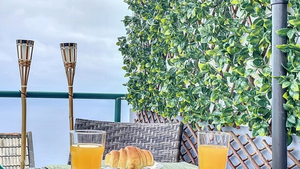 Una mesa servida con cruasanes y jugo de naranja, con vistas a un paisaje pintoresco.
