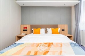 A hotel room with a bed, a nightstand, a phone, and a wall-mounted control panel. - Shell Hotel (Chengyang Agricultural University Subway Station) (Qingdao)