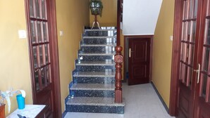 A staircase with a wooden handrail and a potted plant at the top.