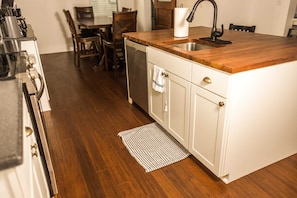 Compact kitchen area with sink, dishwasher, and dining space.