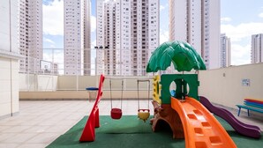 A children's play area with a slide, swings, and a climbing structure. - MFL1802 (Goiânia)