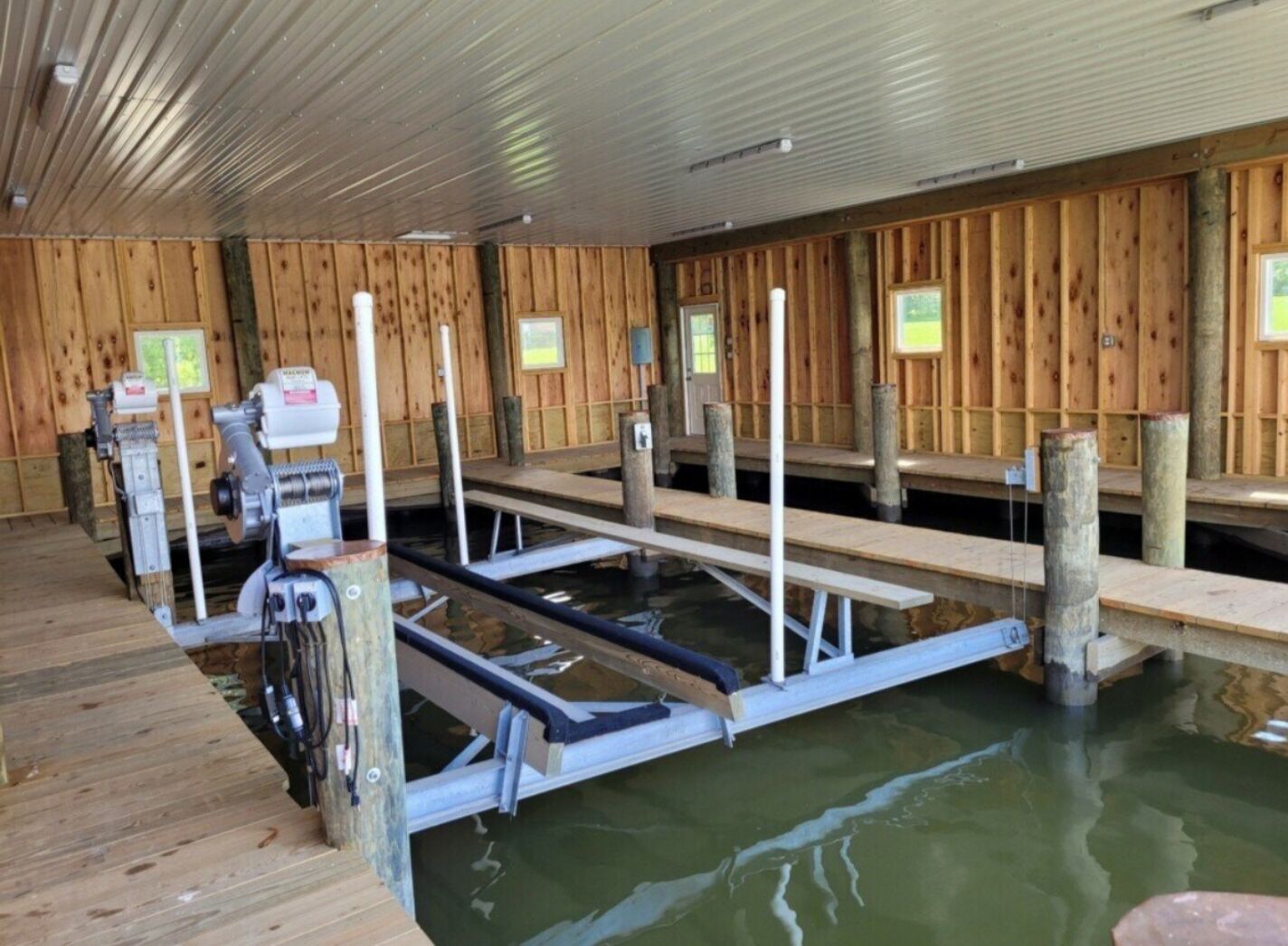 A sauna with wooden walls and benches, a water pool, and a sauna machine.
