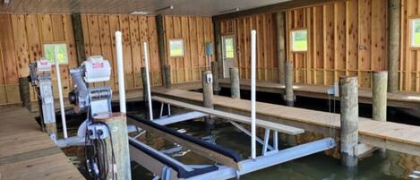A sauna with wooden walls and benches, a water pool, and a sauna machine.